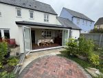 Conservatory with opened bifold doors by Realistic Home Improvements