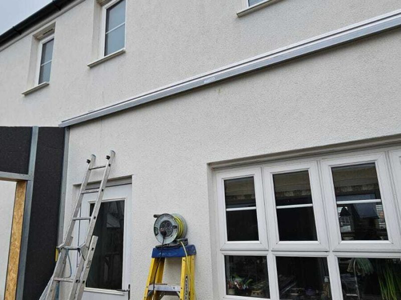 Ladder and tools leaning against wall being used to make conservatory